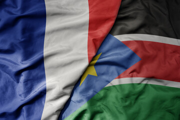 big waving realistic national colorful flag of france and national flag of south sudan .