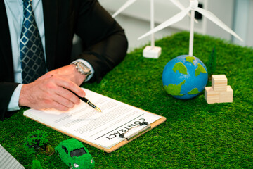 Businessman or CEO in office signing environmental regulation agreement to save Earth with...