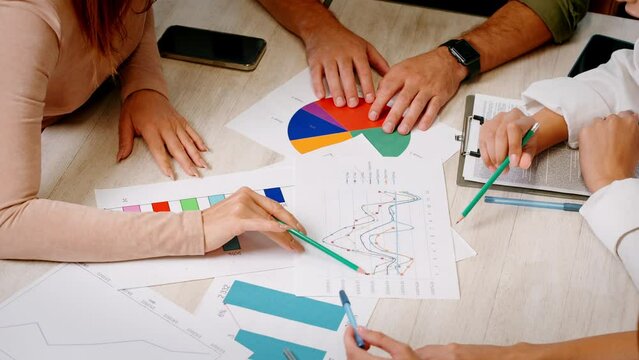 Team of coworkers studies statistical documents in office