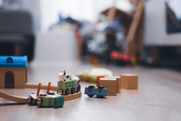 Wooden toy train playing in a hardwood floor playground