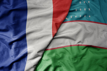 big waving realistic national colorful flag of france and national flag of uzbekistan .