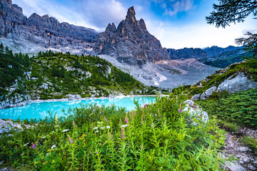 Fototapeta na wymiar Beautiful view on turquoise Sorapis lake and with dito di dio in the background in the evening. Lake Sorapis, Dolomites, Belluno, Italy, Europe.