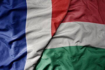 big waving realistic national colorful flag of france and national flag of hungary .