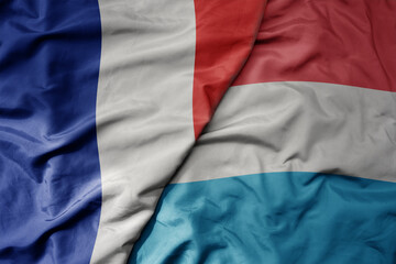 big waving realistic national colorful flag of france and national flag of luxembourg
