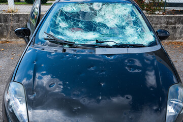 hail damage to car. damaged hood and windshield - obrazy, fototapety, plakaty