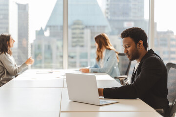 Portrait of pensive serious African American man wearing formal clothes, taking notes in modern office. Successful businessman planning project, attractive student preparing for exam