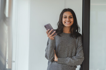 Portrait of beautiful smiling businesswoman wearing casual wear, holding phone