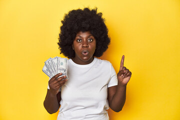 African-American woman holding cash, displaying wealth having some great idea, concept of creativity.