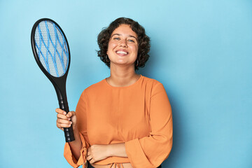 Young woman with electric mosquito racket Young woman with electric mosquito racketlaughing and...