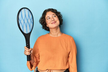 Young woman with electric mosquito racket Young woman with electric mosquito racketdreaming of...