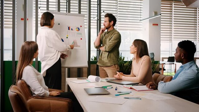 Asian woman intern submits report on project at conference