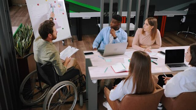 Young manager in wheelchair tells details of new project