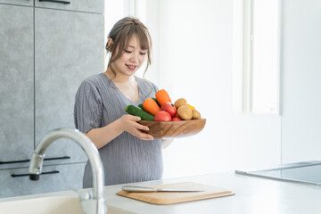 キッチンで野菜を持つアジア人女性・妊婦・プレママ
