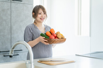 キッチンで野菜を持つアジア人女性・妊婦・プレママ
