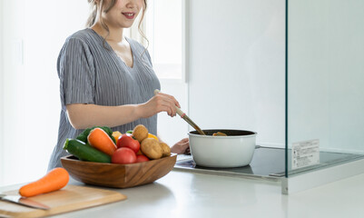 キッチンでカレーを作るアジア人女性・妊婦・プレママ
