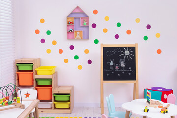Stylish kindergarten interior with toys and modern furniture
