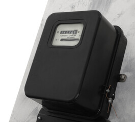 Electricity meter on light grey wall against white background. Space for text
