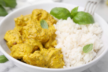 Delicious rice and chicken with curry sauce in bowl, closeup