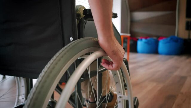 Man with spinal cord injury moves in wheelchair around room