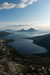 Afternoon view from Smaltinden, Luröy, Helgeland, NordNorge. View over Norwegian island of Tomma, across sjona. Mountains on islands in Norway. Tower of rocks in the foreground. Beautiful Norway hike.