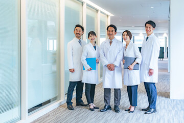 通路に笑顔で並ぶ白衣のグループ　医師　大学医局　病院　科学者