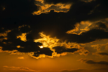 The orange sun trying to peek through the clouds