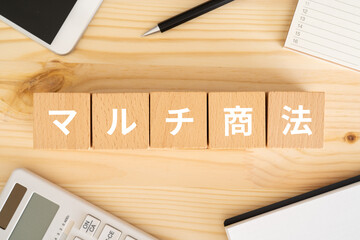 マルチ商法と書かれたブロック、電卓、スマホ、カレンダー