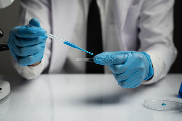 scientist Working in the laboratory using a Micro Pipette. Mixing liquid chemicals with genetically modified samples under a microscope biotechnology, microbiology development, research experiments.