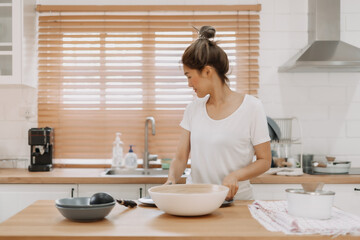 Asian woman preparing meal in the kitchen.