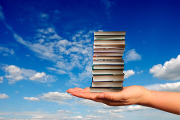 hand holding a stack of books 