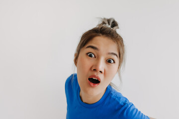Shocked funny asian face of woman feeling unbelievable isolated on white.