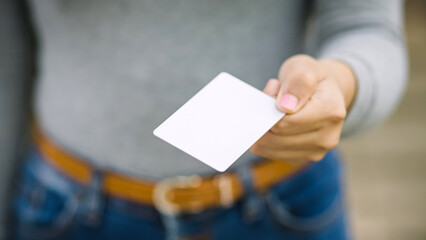 Young female holding blank credit card, outdoor