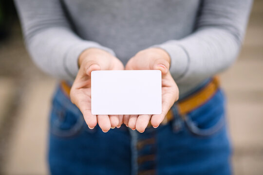 Young female holding blank credit card, outdoor