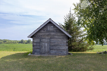 Rural landscape view of a 19th century log cabin on the prairie in midwestern United States