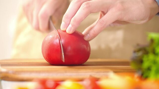トマトを切る若い男性　料理イメージ