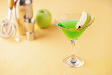 Alcoholic cocktail apple martini or green sour appletini in martini glass . Bar tools.
