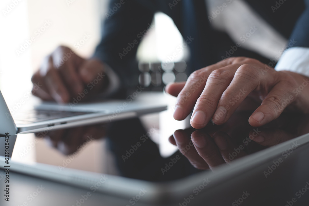 Wall mural close up of business man hand using digital tablet and working on laptop computer. business man surf