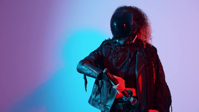 A fashion portrait of a black woman with a Japanese sword shot in a studio with colorful lighting. Ninja and samurai cosplay.