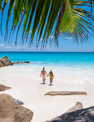 Fototapeta na wymiar Anse Lazio Praslin Seychelles, a young couple of men and women on a tropical beach during a luxury vacation in Seychelles. Tropical beach Anse Lazio Praslin Seychelles Islands