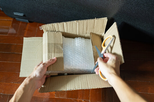 Opening cardboard parcel box with scissors