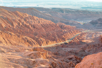 Road between red rocks near San Pedro de Atacama during sunset