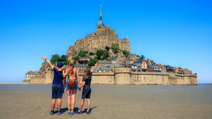 Family traveling in France- famous touristic of Le Mont Saint Michel - Normandy - obrazy, fototapety, plakaty