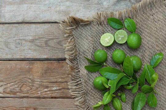 Green limes on wooden table, citrus fruits, background image, free space, top view, background, for presentations