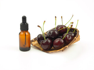 Brown bottle eye dropper and fresh cherries on wicker besket isolated on white background. Concept of cosmetic product design or skin care cream. .