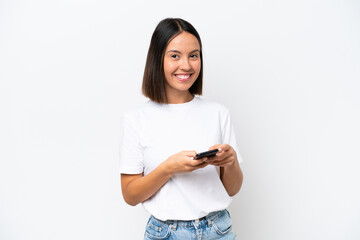 Fototapeta premium Young caucasian woman isolated on white background sending a message with the mobile