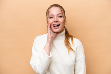 Young caucasian woman isolated on beige background with surprise and shocked facial expression