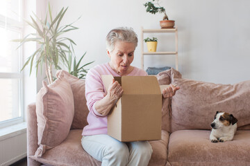Smiling older adult mature woman customer unpacking parcel