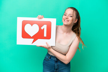 Young caucasian woman isolated on green background holding a placard with Like icon with happy expression