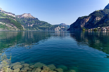 Scenic view of Lake Lucerne with Swiss Alps and mountain panorama seen from lakeshore of village Flüelen on a sunny spring day. Photo taken May 22nd, 2023, Flüelen, Switzerland.