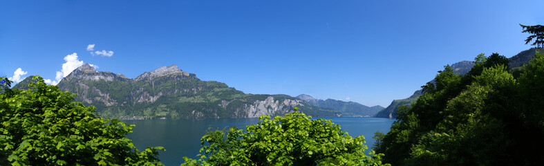 Fototapeta na wymiar Scenic. wide angle landscape in the Swiss Alps with Lake Lucerne in the foreground and mountain panorama in the background on a sunny spring day. Photo taken May 22nd, 2023, Lake Uri, Switzerland.